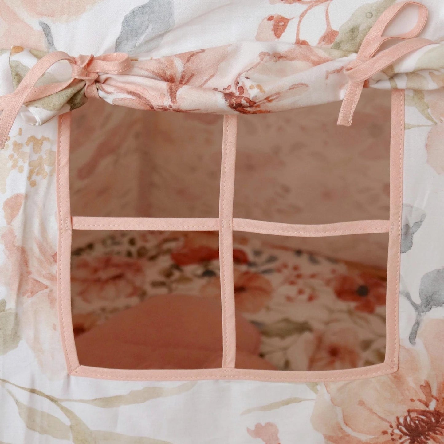 Floral crib set with pink trim and mesh sides.