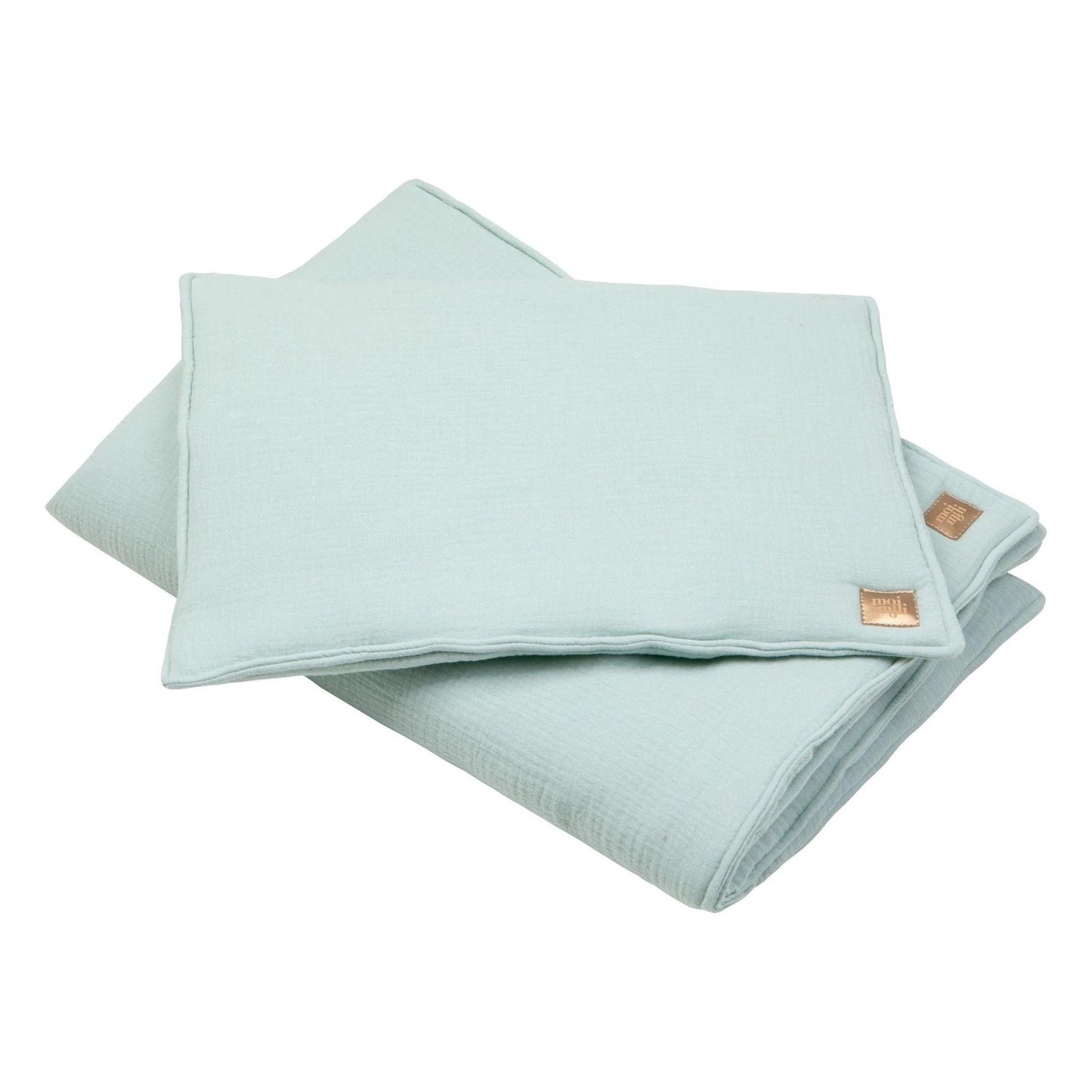 Folded light blue fabric with two gold buttons on a white background