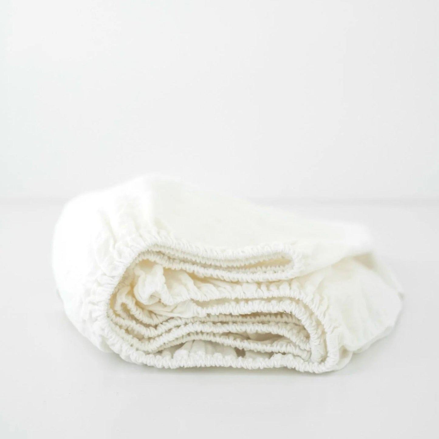 Folded white towel on a light gray background