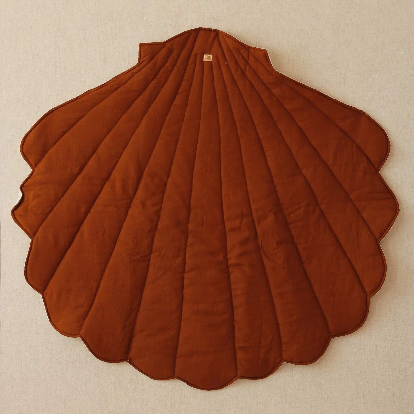 Brown scalloped rug on a beige wall