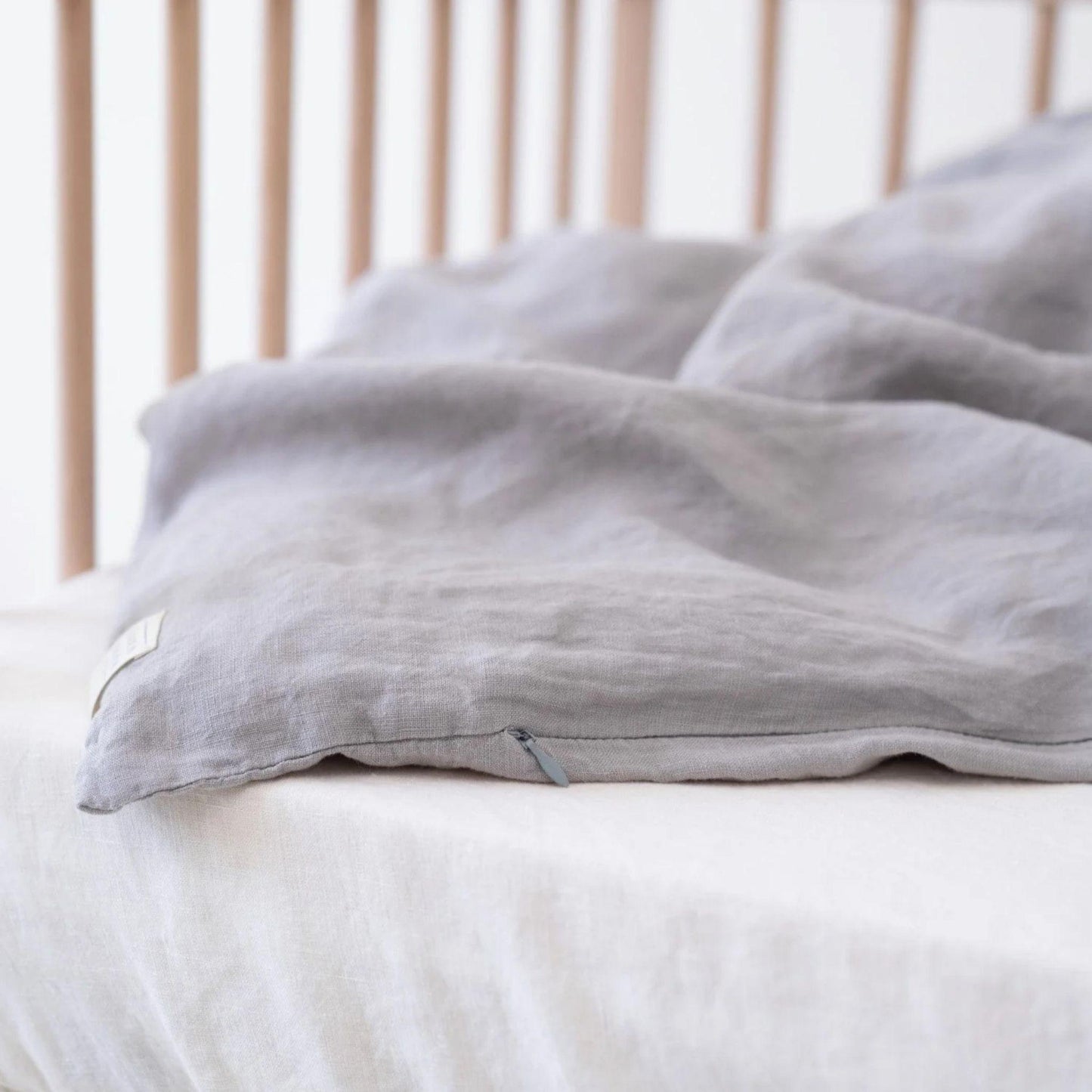 Gray weighted blanket on a bed with a wooden headboard