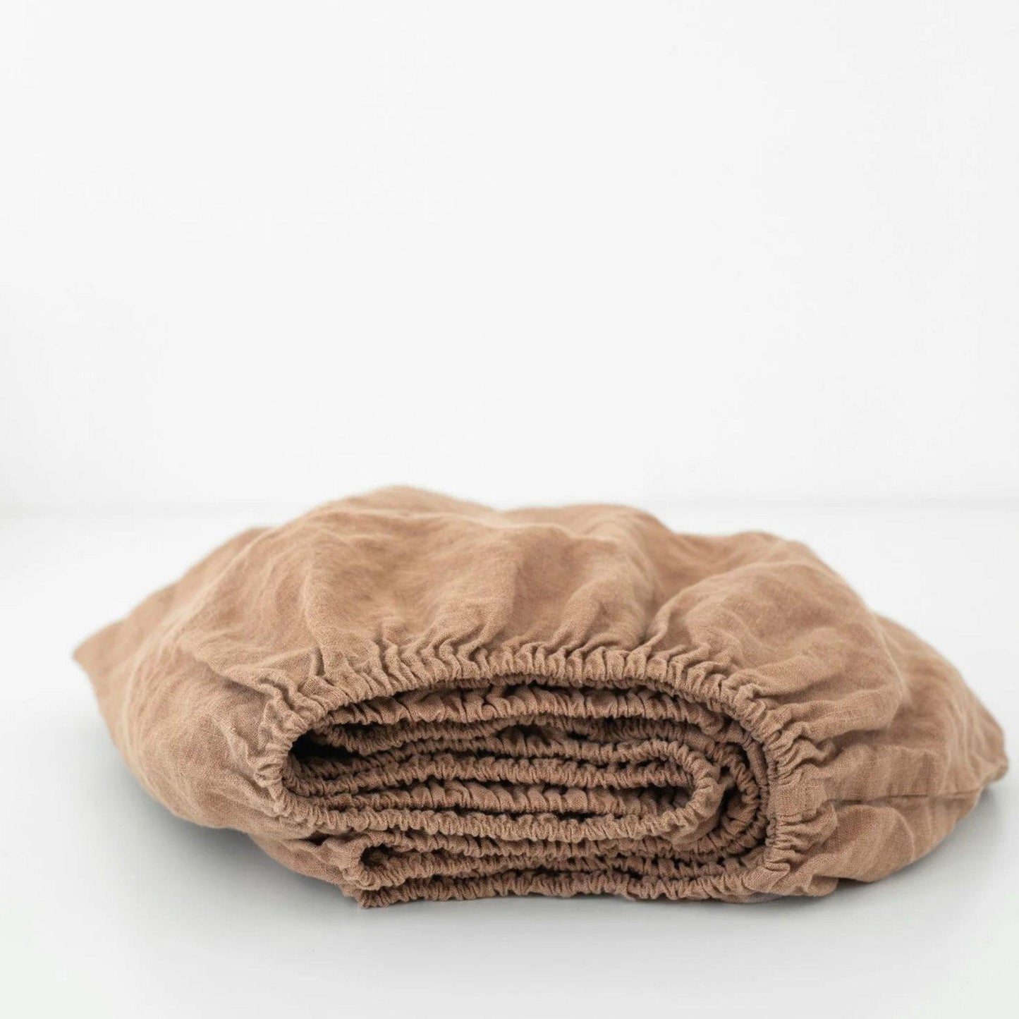 Folded beige blanket on a white background