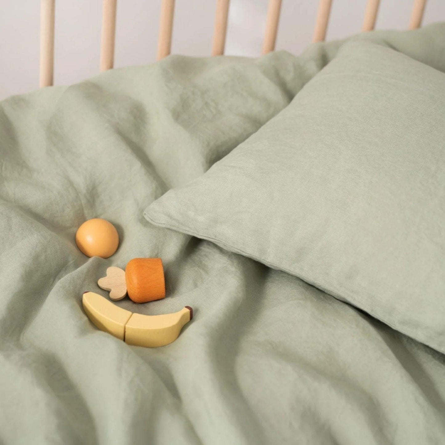 Wooden toys on a green blanket with a white background