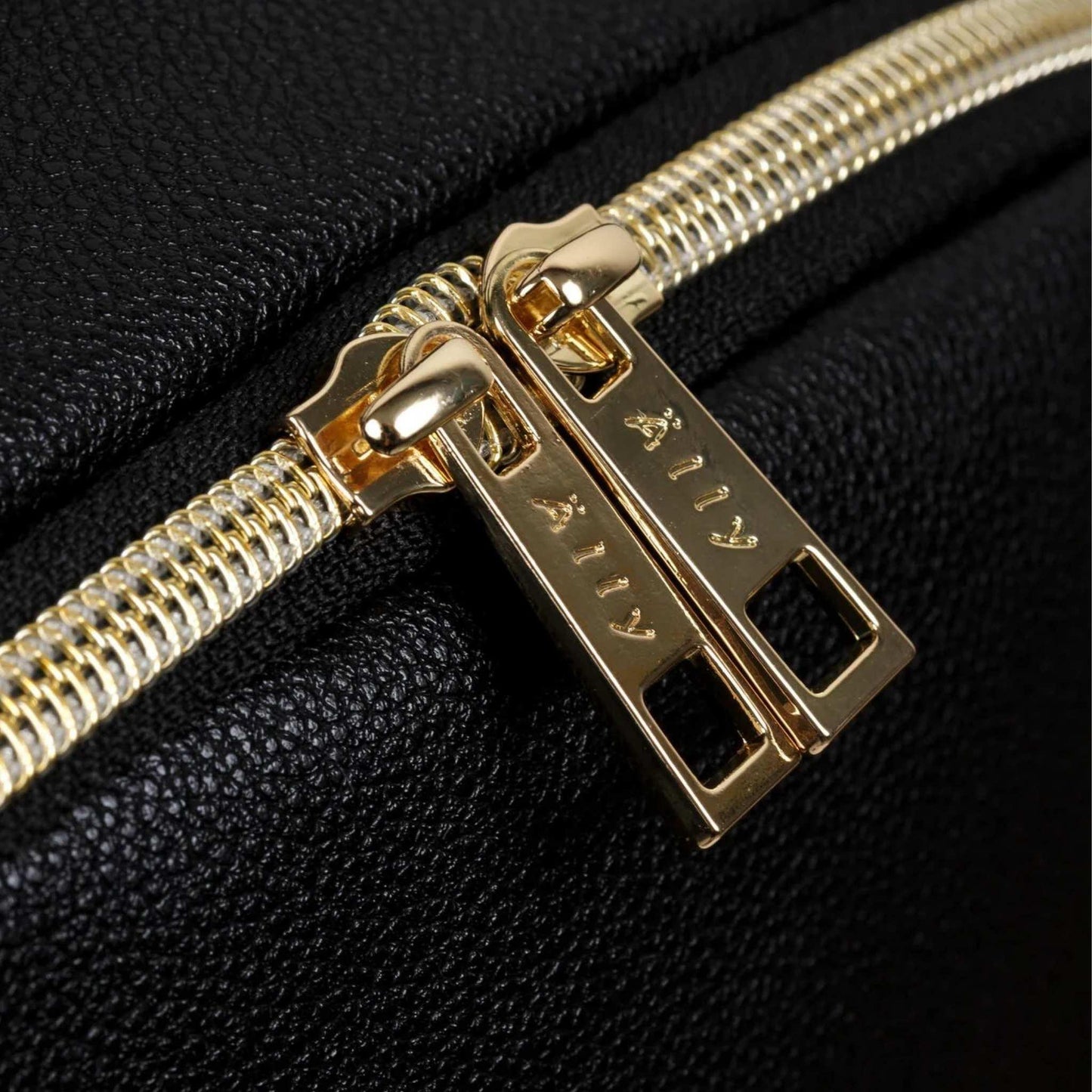 Gold zipper pull on a black textured background