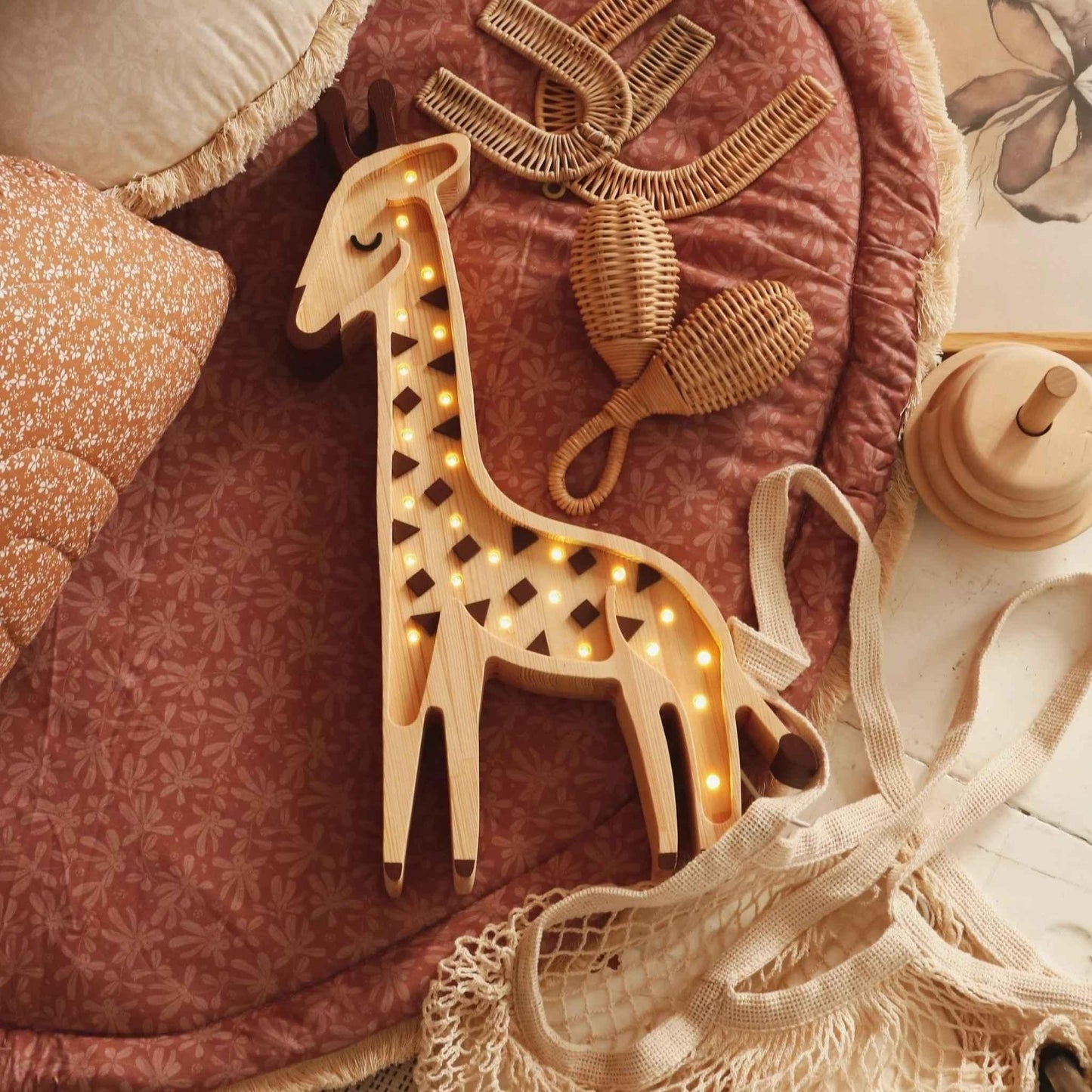 Wooden giraffe-shaped lamp with lights on a textured surface