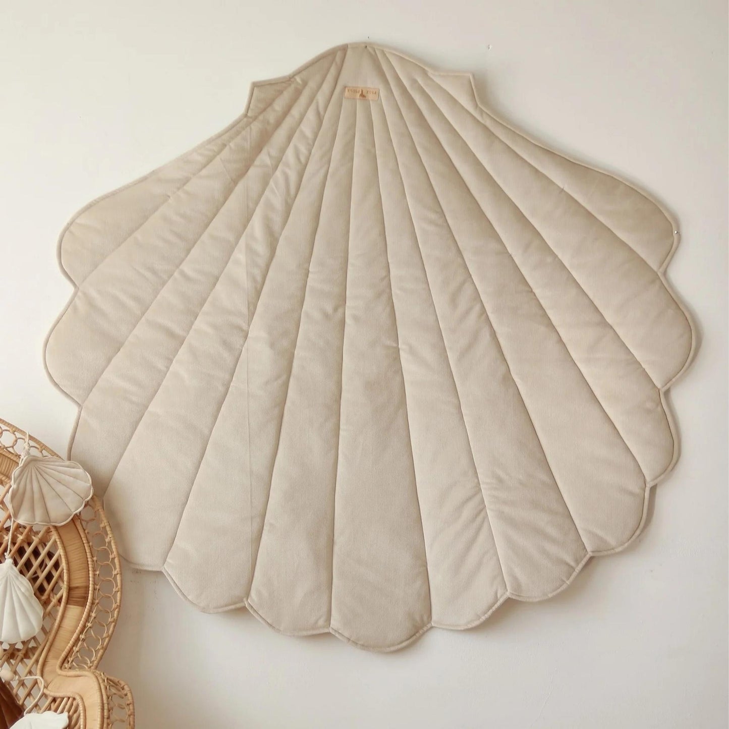 Beige shell-shaped cushion on a light background