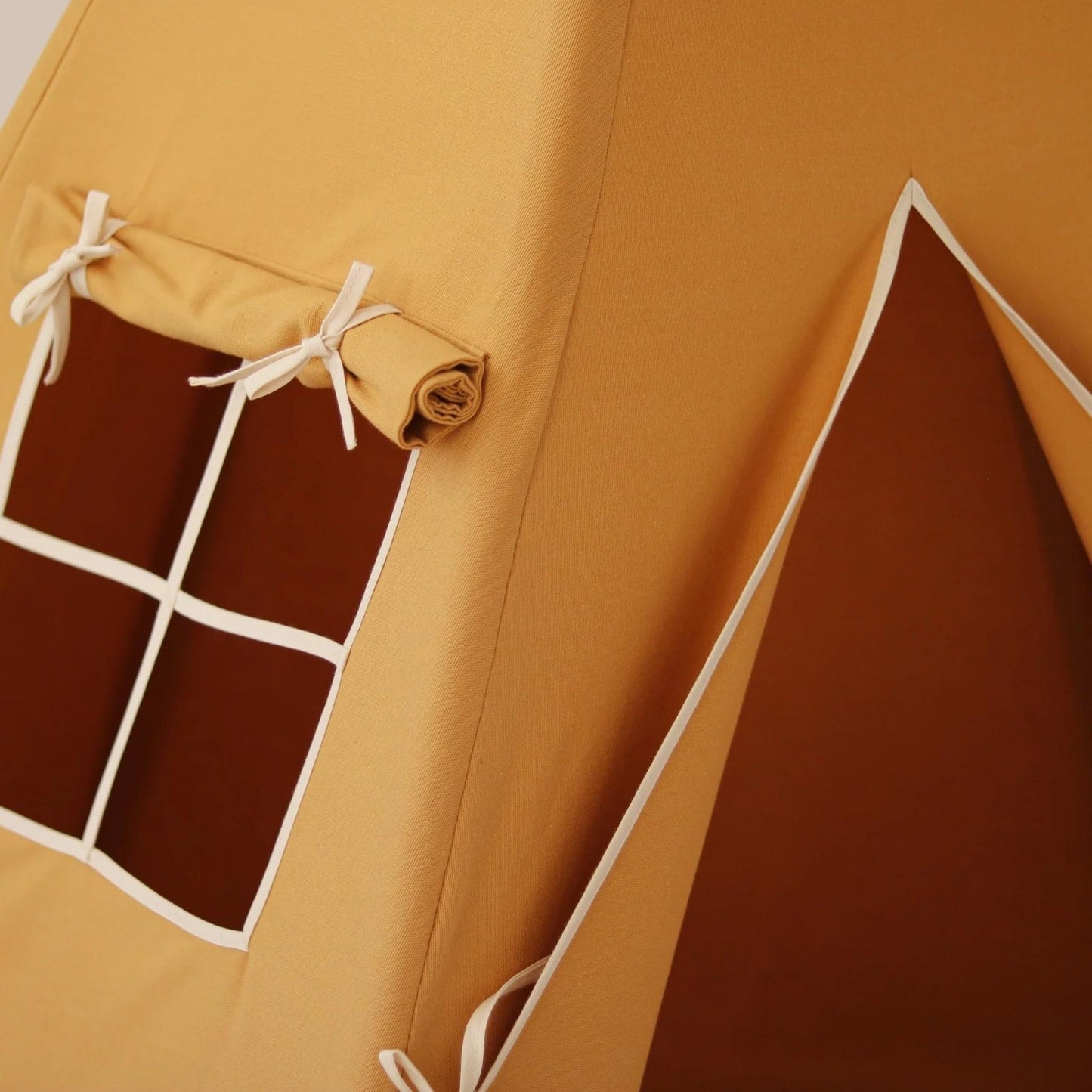 Close-up of a yellow tent with a brown interior and white strings.