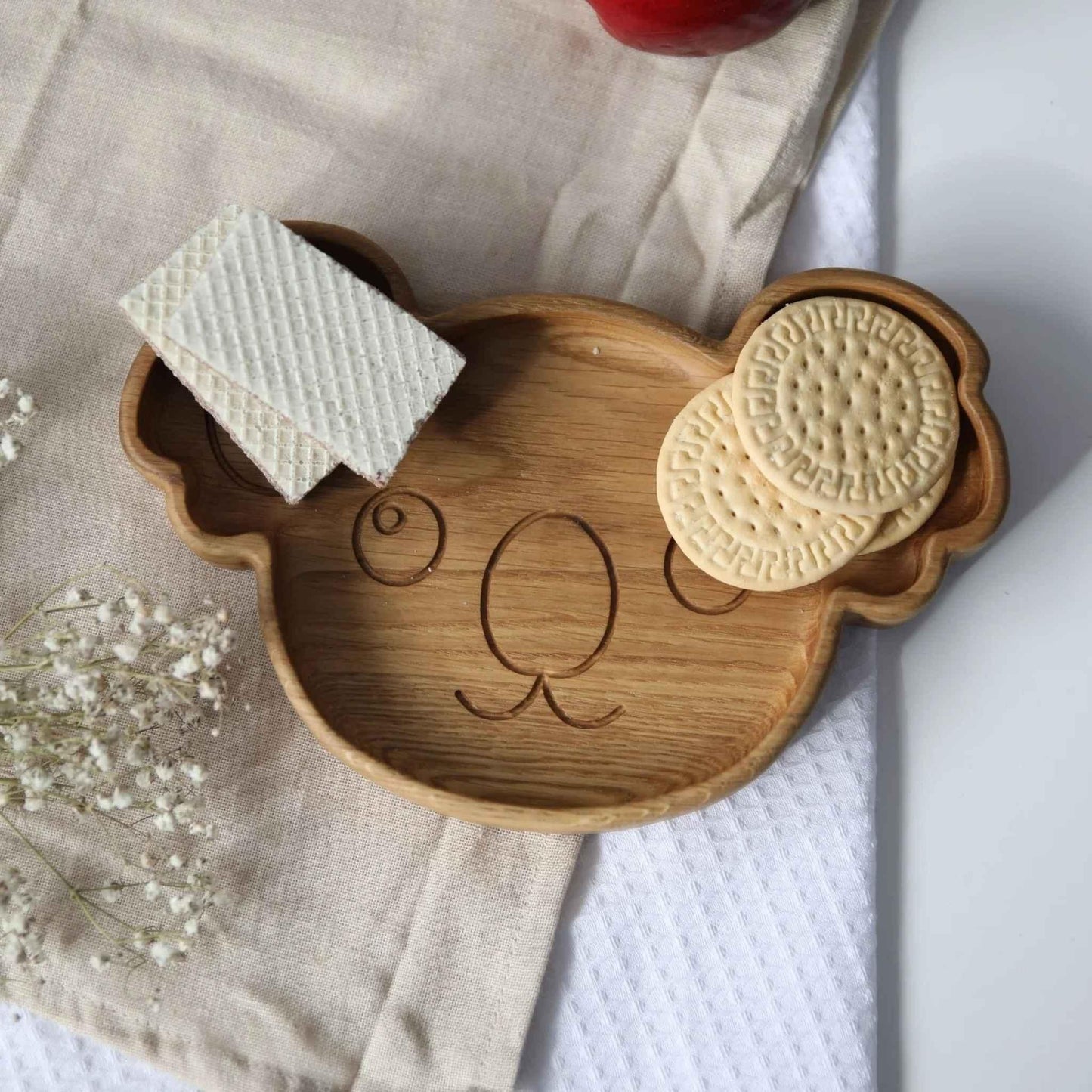 Wooden tray shaped like a bear with cookies on a light background