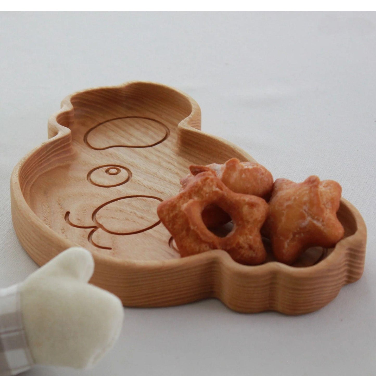 Wooden bear-shaped tray with star-shaped cookies on a white background