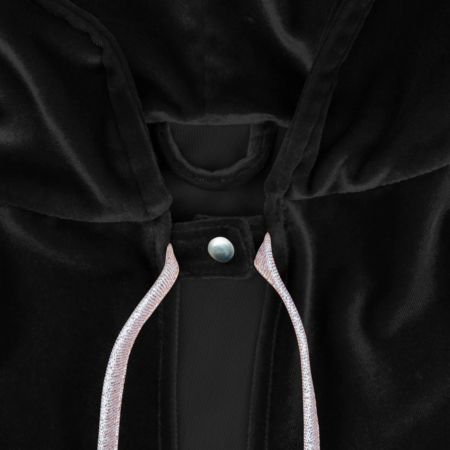 Close-up of a black garment with a button and white trim on a dark background