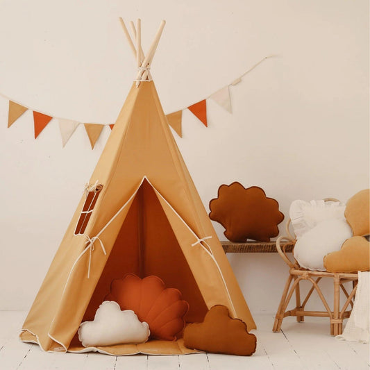 Children's teepee with decorative pillows and a small table in a room.