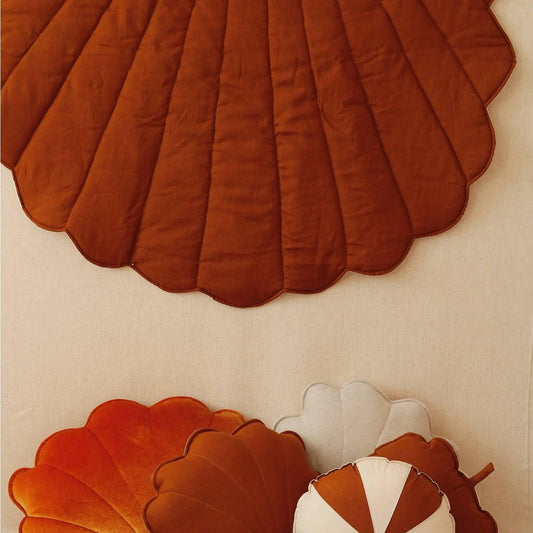 Decorative wall art with scalloped shell shapes in brown and white on a beige background