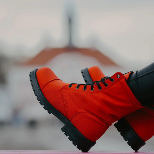 Red boots with black soles on a blurred background