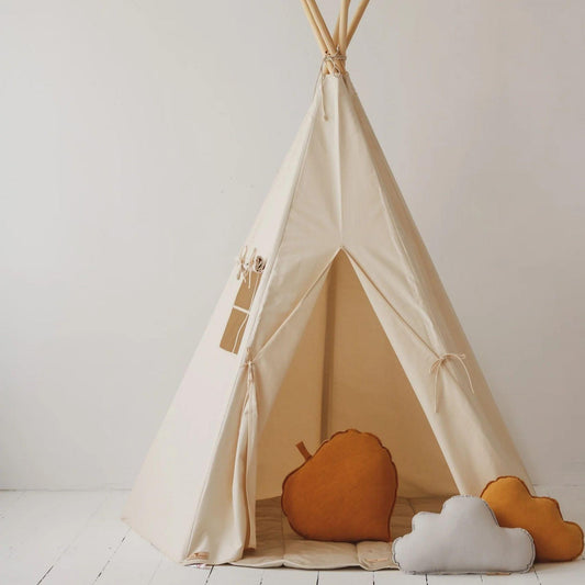 Beige children's teepee with orange and white cushions on a white floor and background