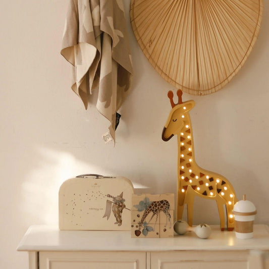 Decorative giraffe lamp on a shelf with a neutral background