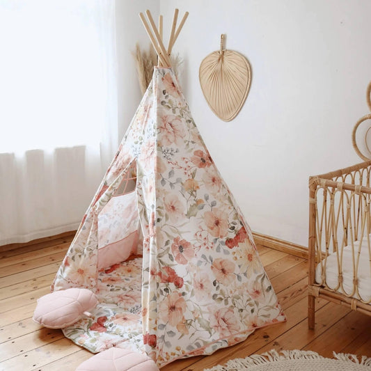 Floral-patterned teepee in a child's room with a crib and decorative wall hanging.