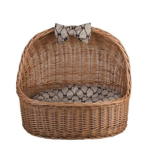 Wicker pet bed with a bow tie on a white background