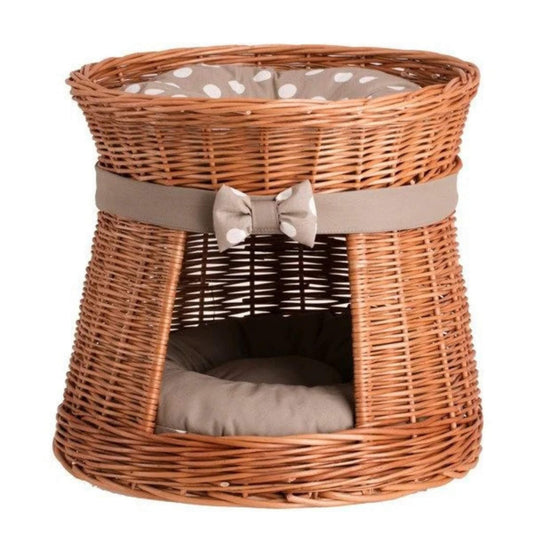 Wicker pet bed with a cushion and decorative bow on a white background