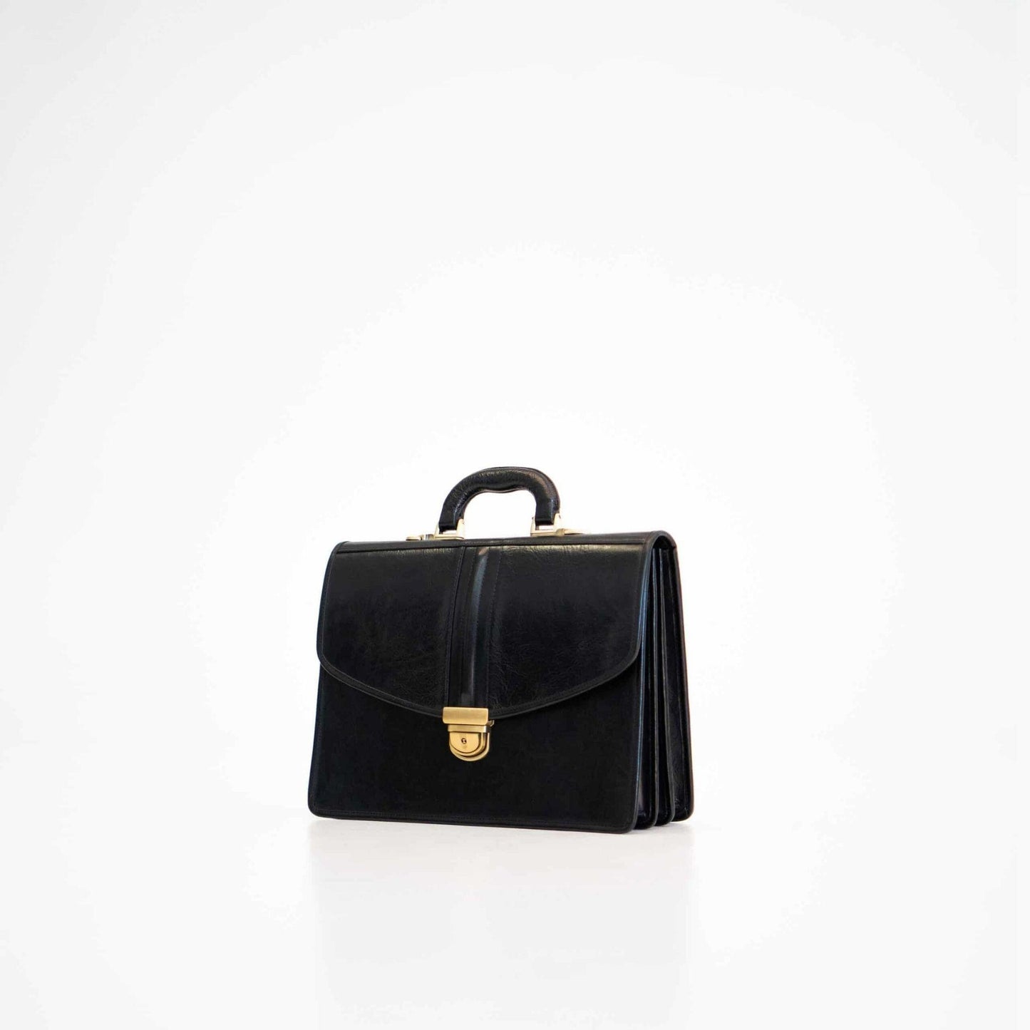 Black handbag with gold clasp on a white background