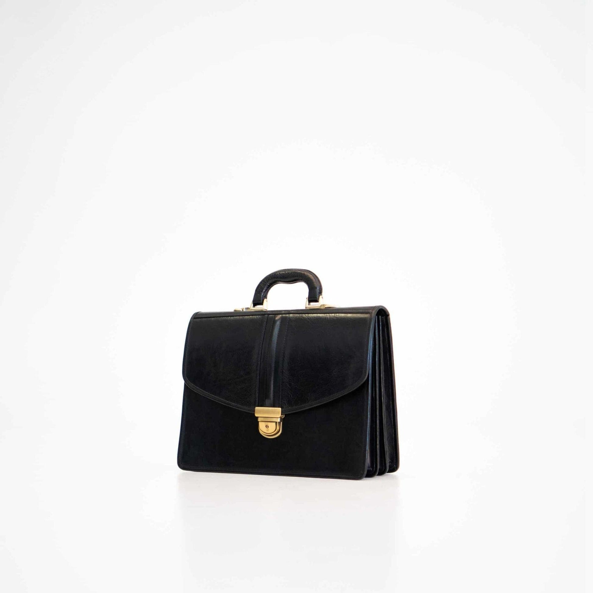 Black handbag with gold clasp on a white background