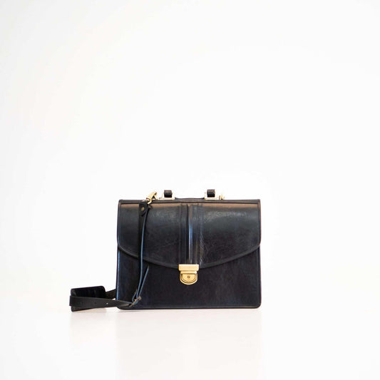 Black handbag with gold clasp on a white background