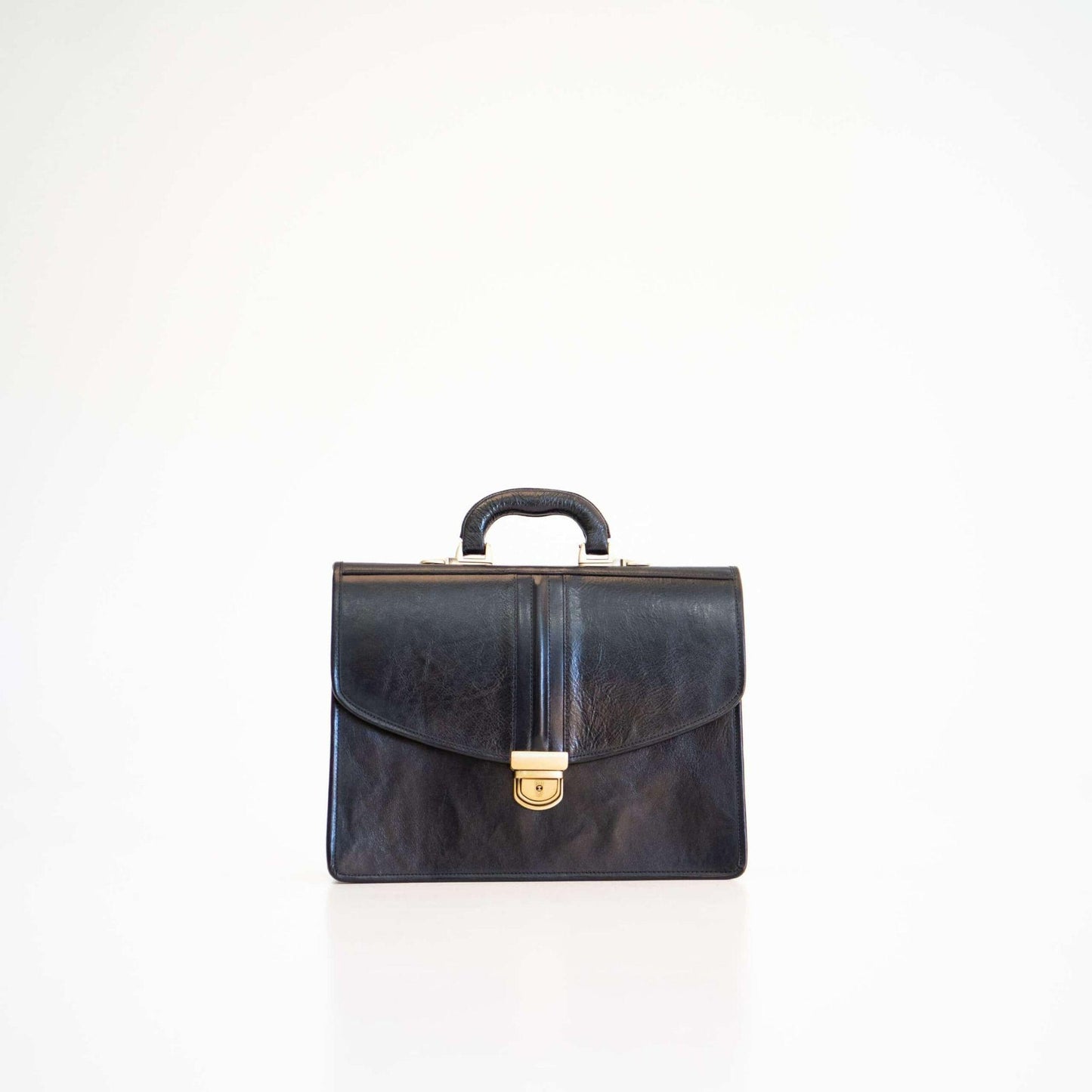 Black leather briefcase with gold clasp on a white background