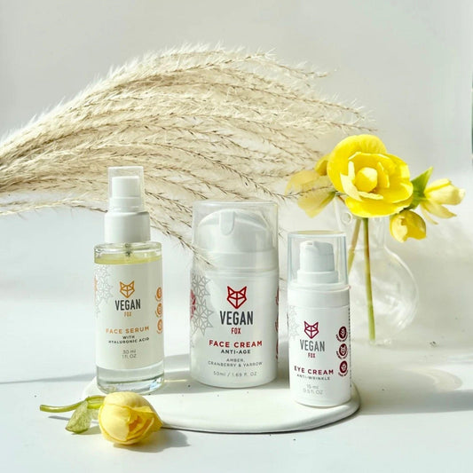 Three vegan skincare products on a white surface with decorative elements.